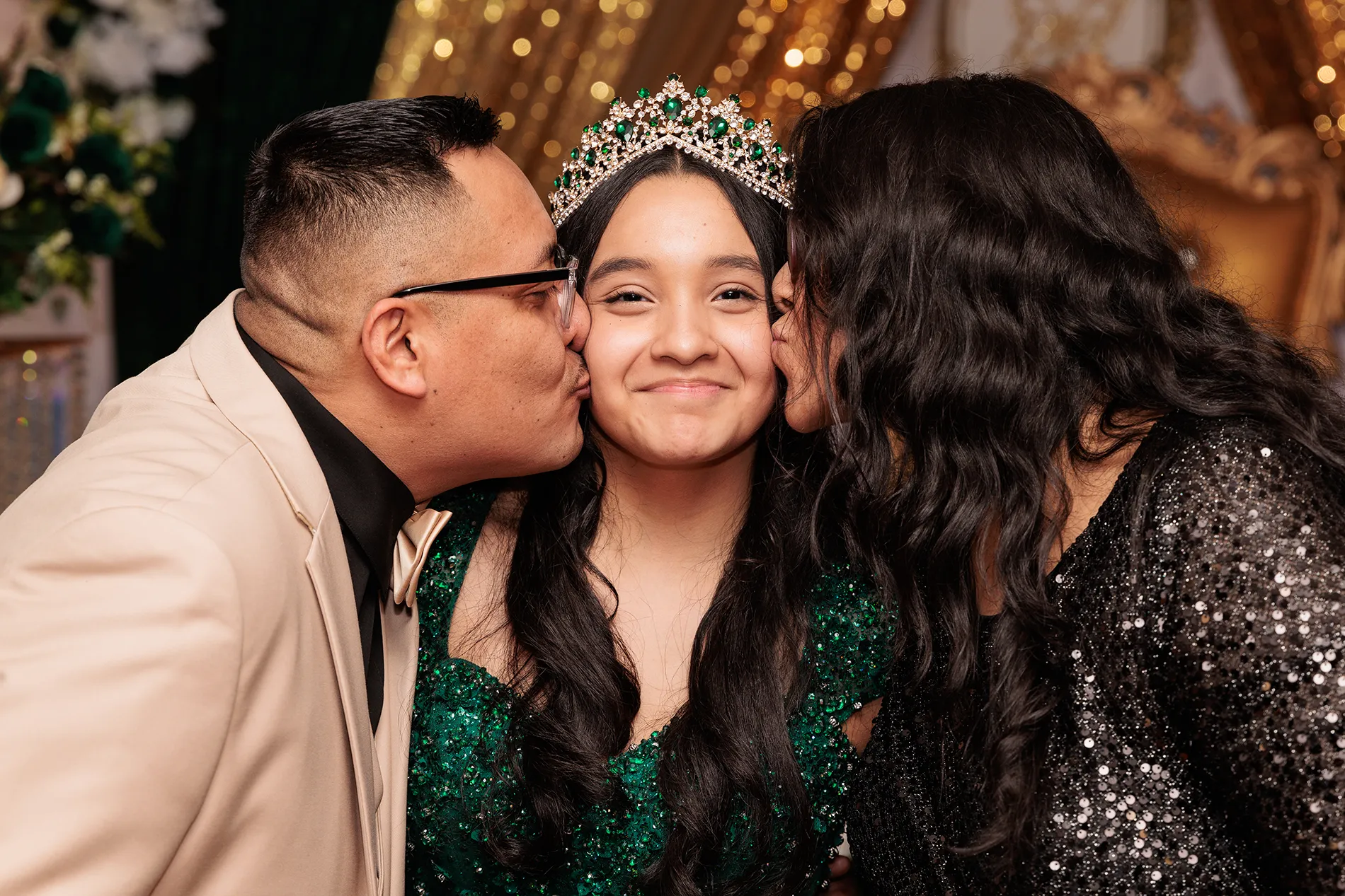 Sweet 16 photography in Jeffersonville NY — quinceañera Elizabeth receiving kisses from her parents during her celebration, captured by Granados Graphics | Fotografía de quinceañeras en Jeffersonville NY con familia besando a la homenajeada.