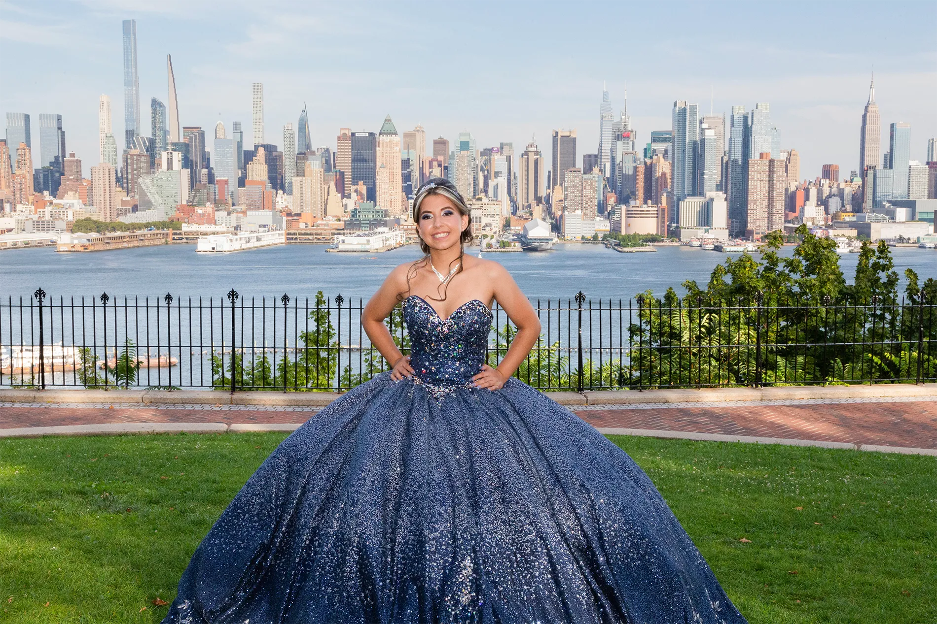 Quinceañera photoshoot overlooking the New York City skyline — Fabiola in a sparkly blue ball gown posing at a scenic viewpoint in New Jersey | Sesión de fotos de quinceañera con vista al skyline de Nueva York desde New Jersey.