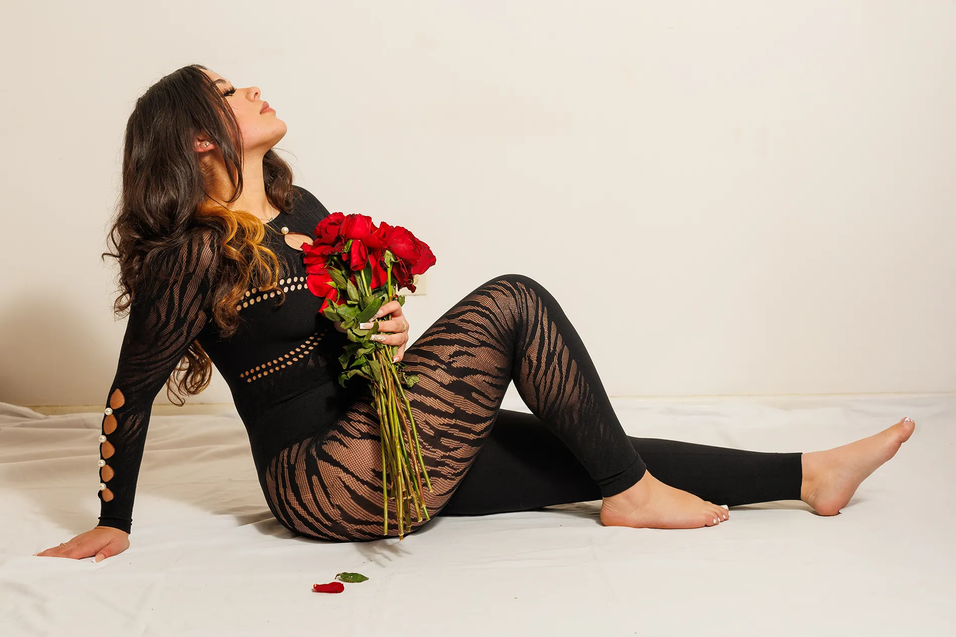 Katie holding red roses in a dramatic black outfit, photographed in a Monticello, NY studio.